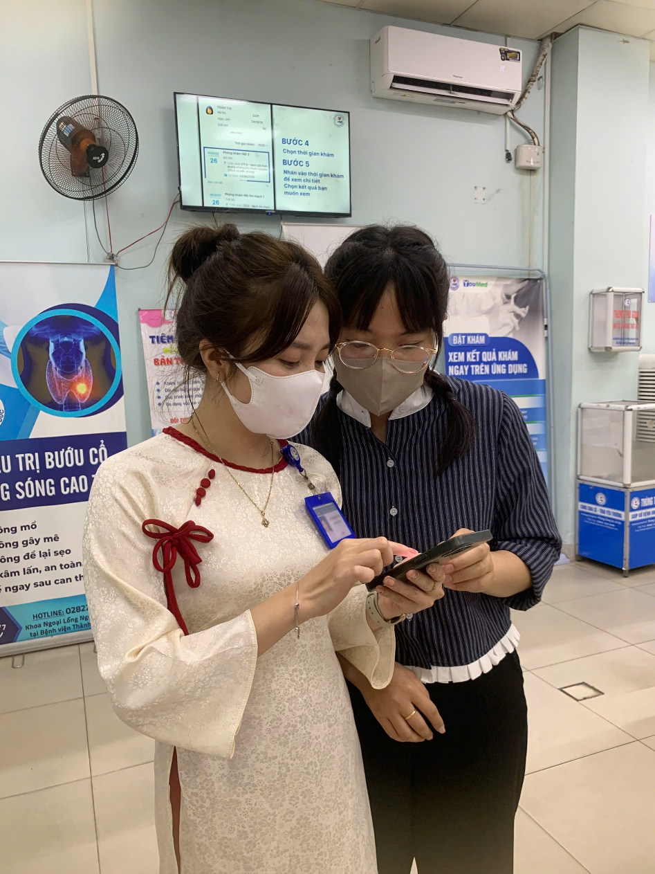 Hình ảnh 2: Nhân viên CSKH hướng dẫn người bệnh đăng ký khám qua ứng dụng di động